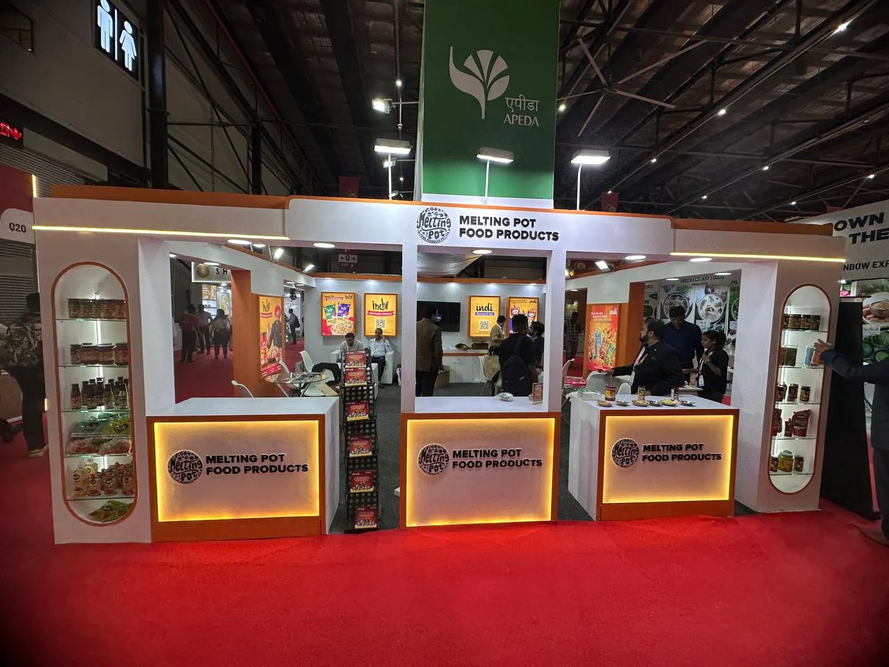 Front view of the completed Melting Pot Food stall showing three illuminated counters and arched product shelving